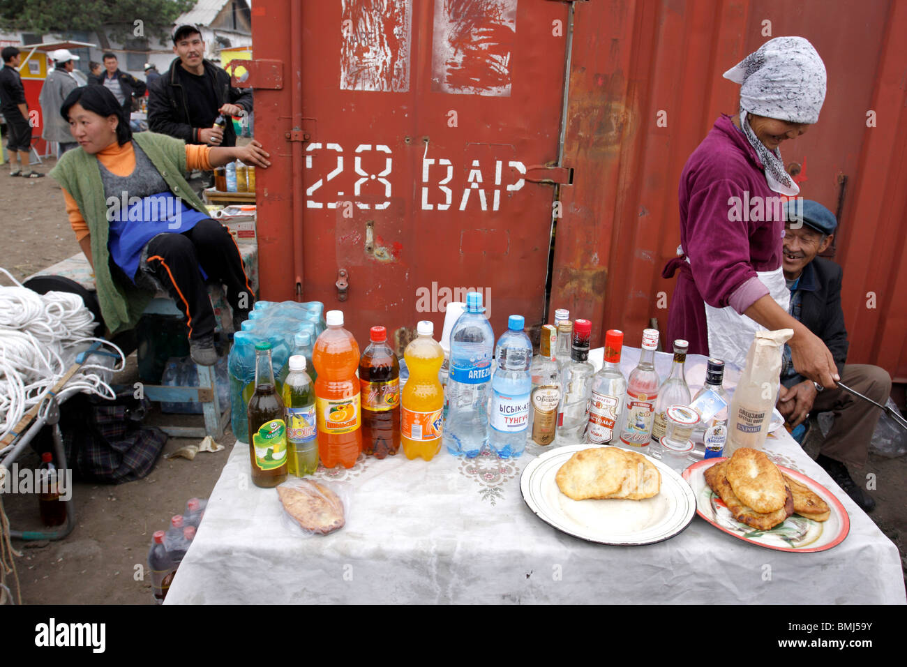 Cibo, bevande e alcol venditore al mercato degli animali in Karakol, Kirghizistan Foto Stock