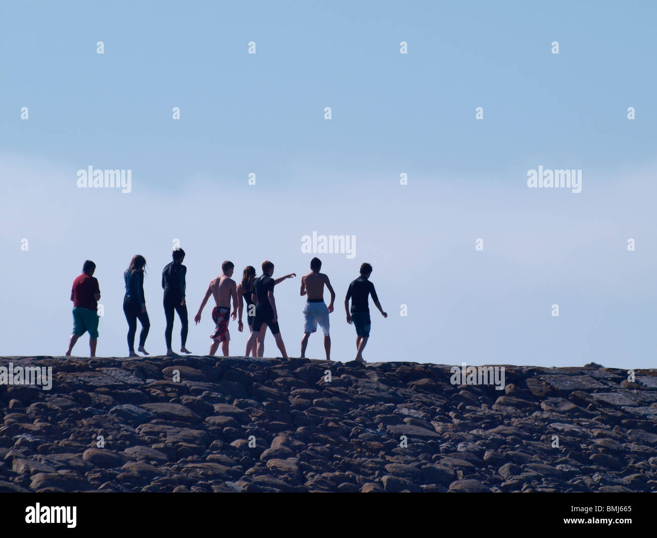 Gli adolescenti a piedi lungo la parete del mare Foto Stock