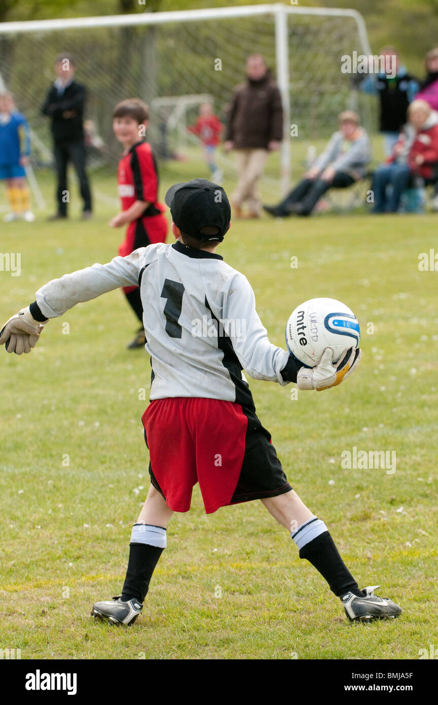 Il portiere lancia la palla - ragazzi adolescenti che giocano a calcio gioco di calcio Sport UK Foto Stock