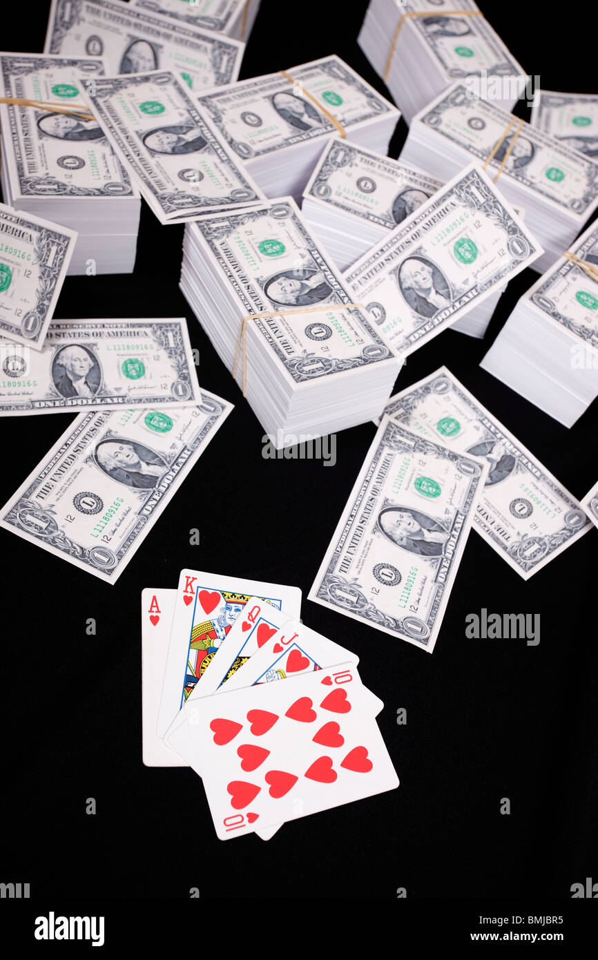 Pile di denaro e carte da gioco Foto Stock