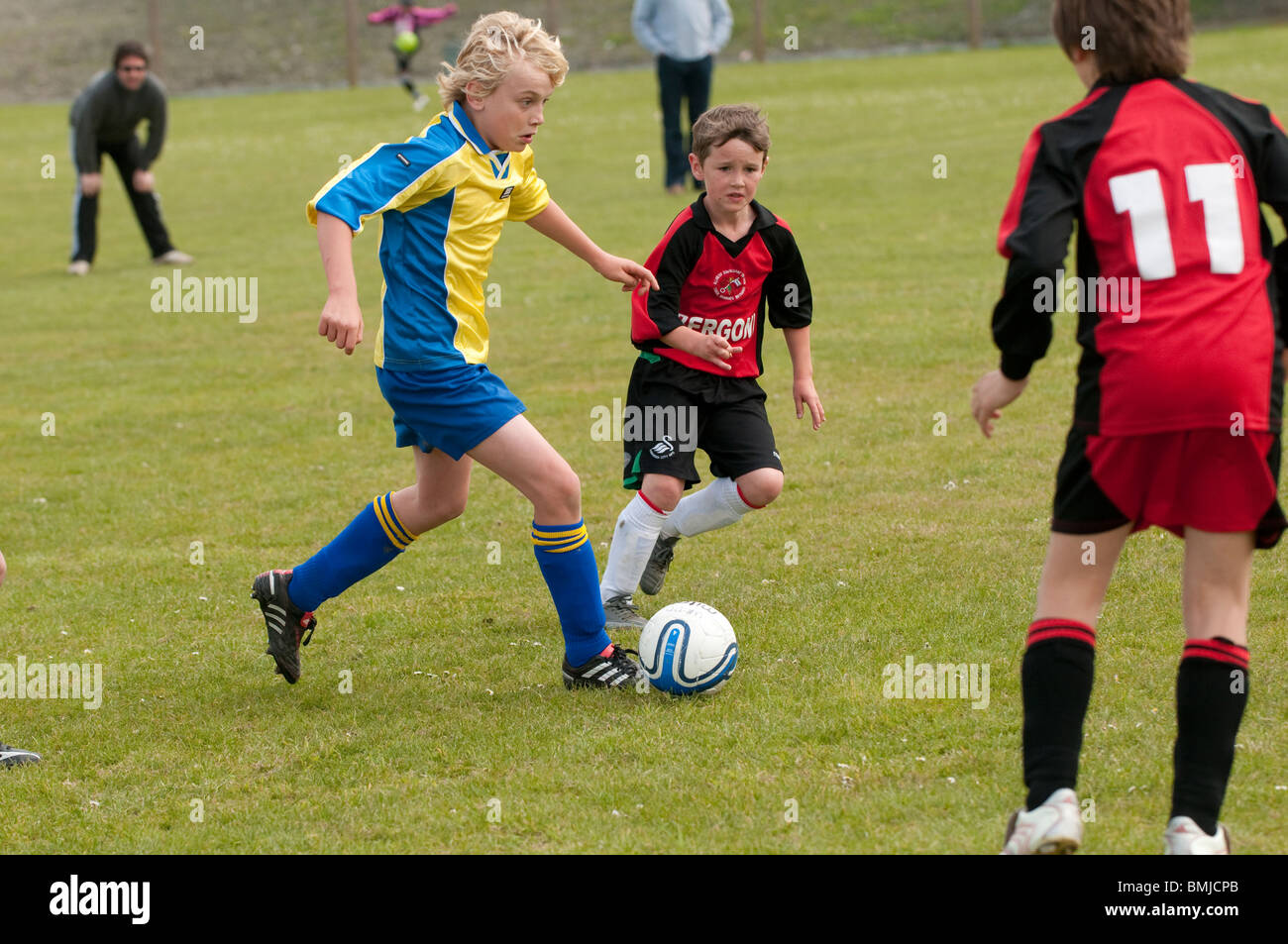Tre bambini figli adolescenti che giocano a calcio gioco di calcio Sport UK Foto Stock