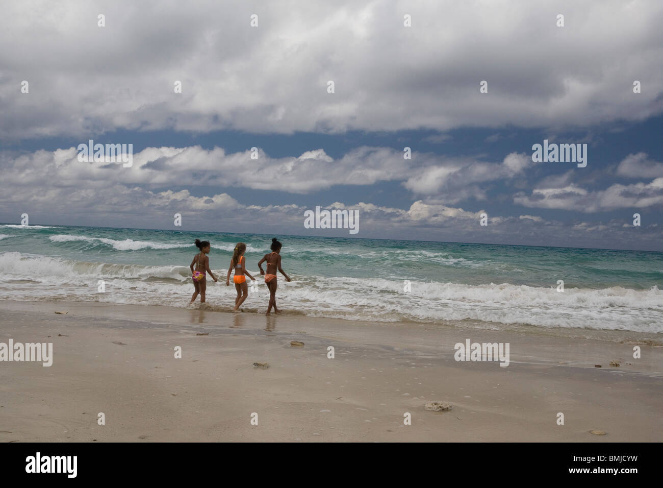 Bambine giocare nel surf a Playas del Este, Cuba. Foto Stock