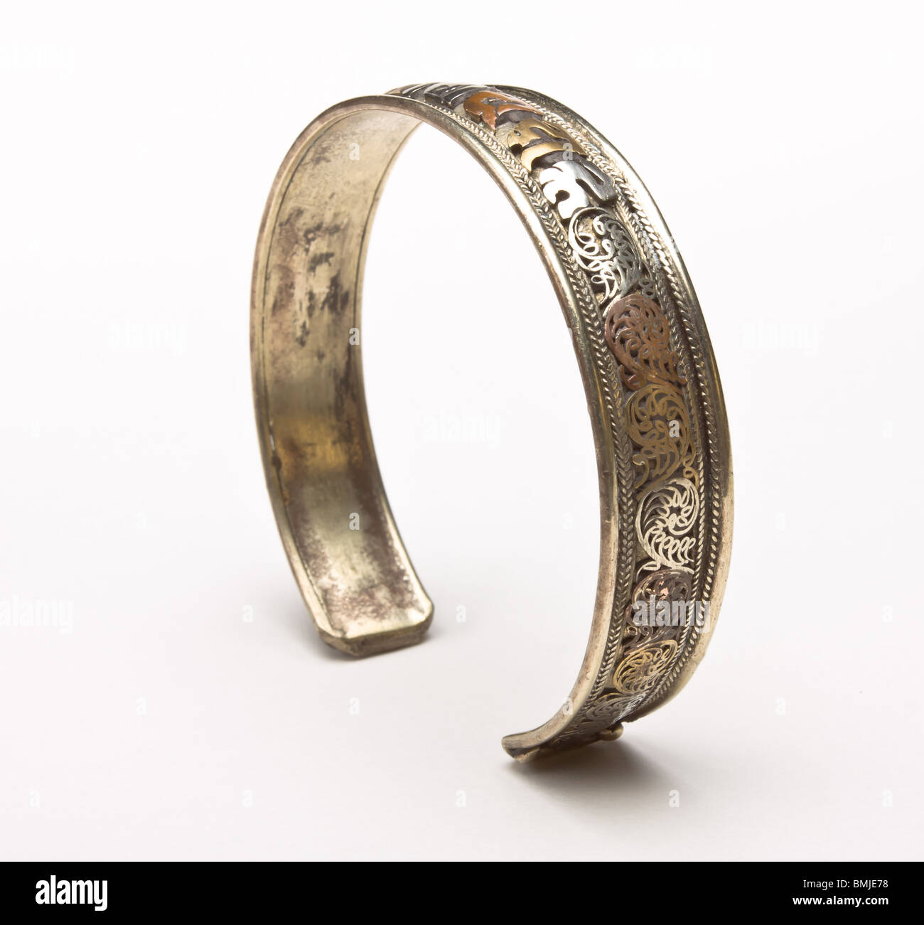 3 in metallo colorato coppia bangle dal Nepal con mantra motivo da basso prospettica isolata contro uno sfondo bianco. Foto Stock