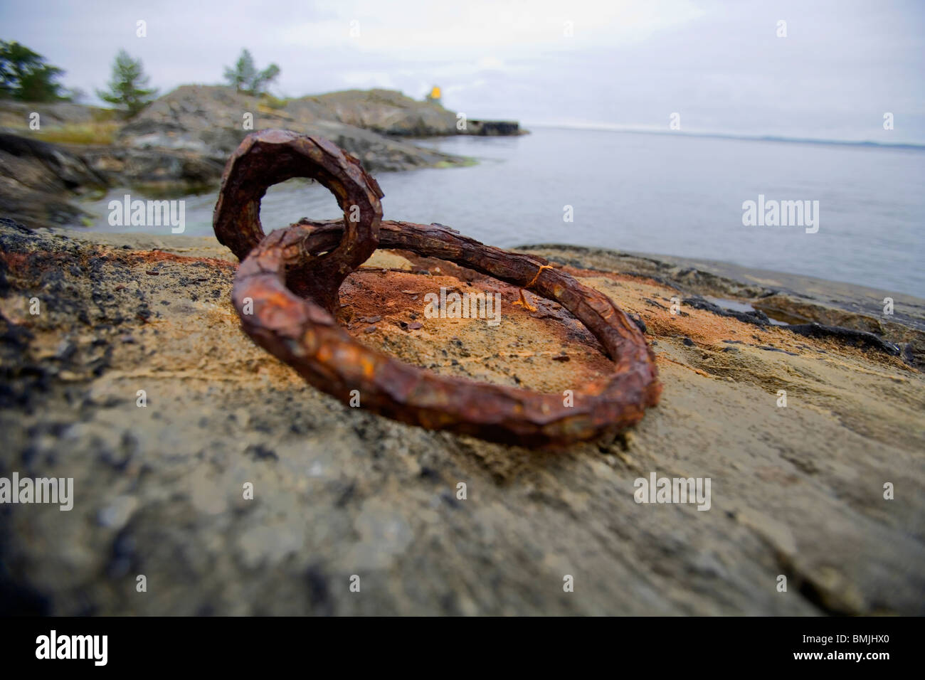 Vista del metallo arrugginito anello con mare in background Foto Stock