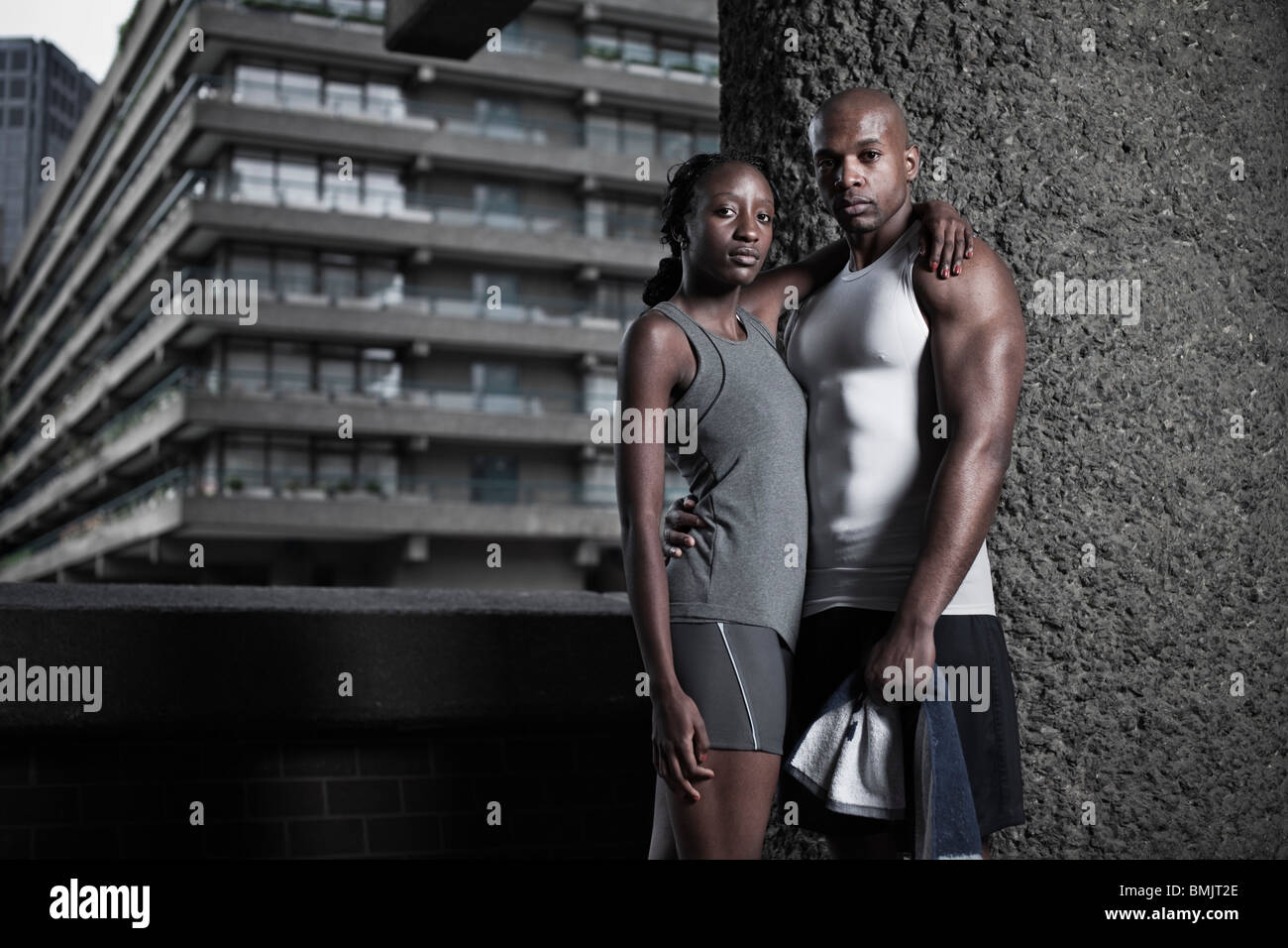 Ritratto di atletica l uomo e la donna vestita in abbigliamento sportivo su city break di alloggiamento Foto Stock