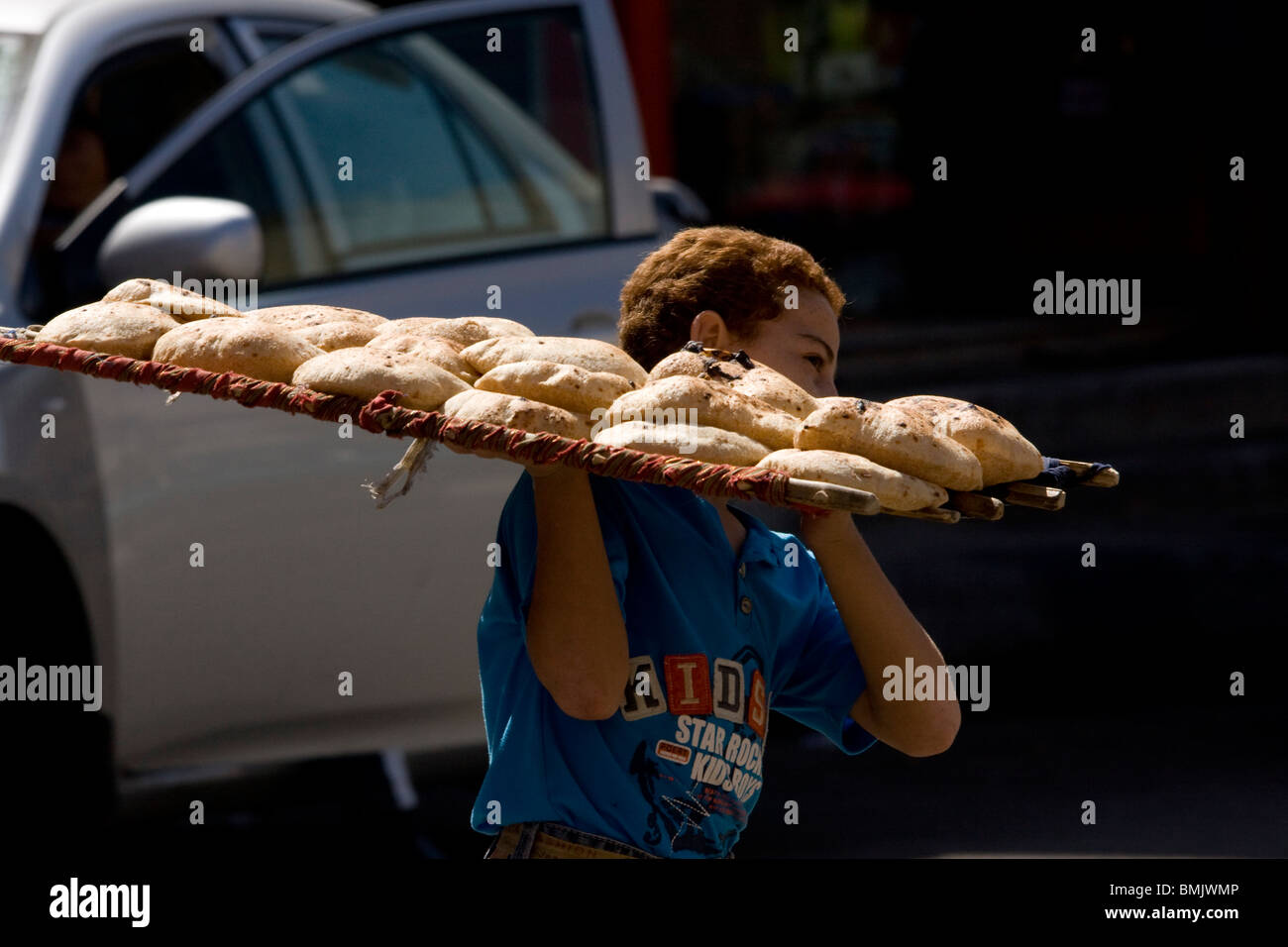 Ragazzo che porta pane pita nel souk, Aswan, Egitto Foto Stock