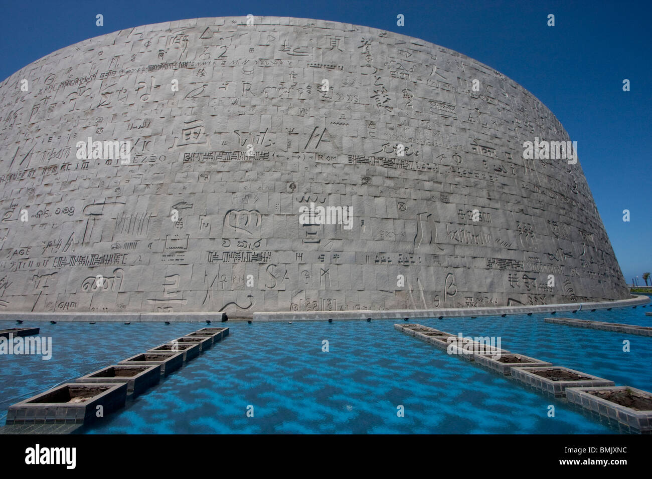 Piscina e scolpito a mano la parete di granito con pietre della Bibliotheca Alexandrina, la moderna biblioteca di Alessandria, Alessandria Foto Stock