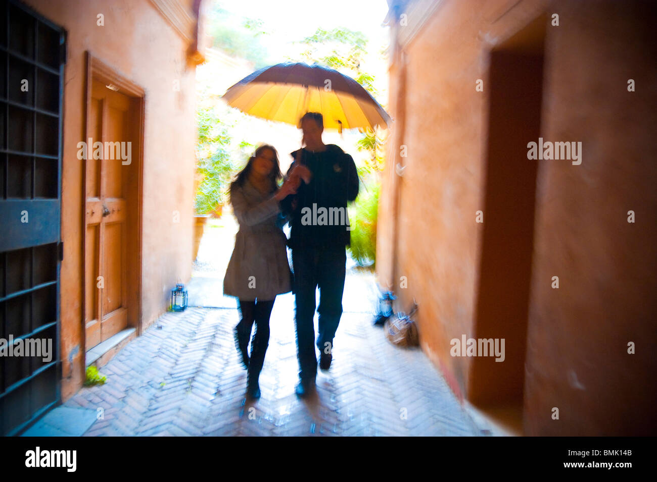 Giovane con motion blur camminando insieme con un ombrello sotto la pioggia a Roma Italia Foto Stock