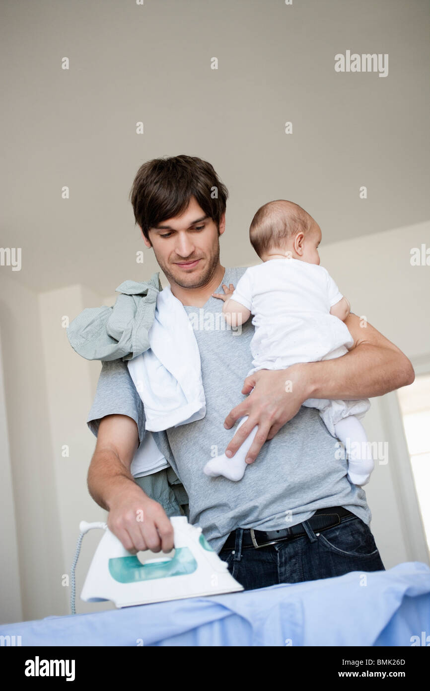 Padre con il bambino in braccio la stiratura Foto stock - Alamy