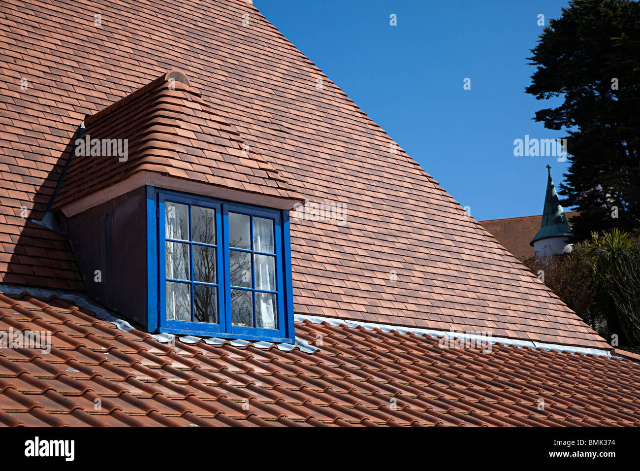 Dipinto di blu gable finestra tetto con tegole rosse parte del monastero cistercense di Caldey Island Wales UK Foto Stock