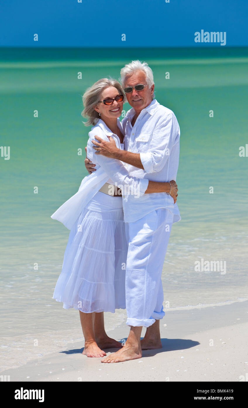 Romantica e felice senior l uomo e la donna giovane vestito di bianco e  abbracciando su una deserta spiaggia tropicale Foto stock - Alamy