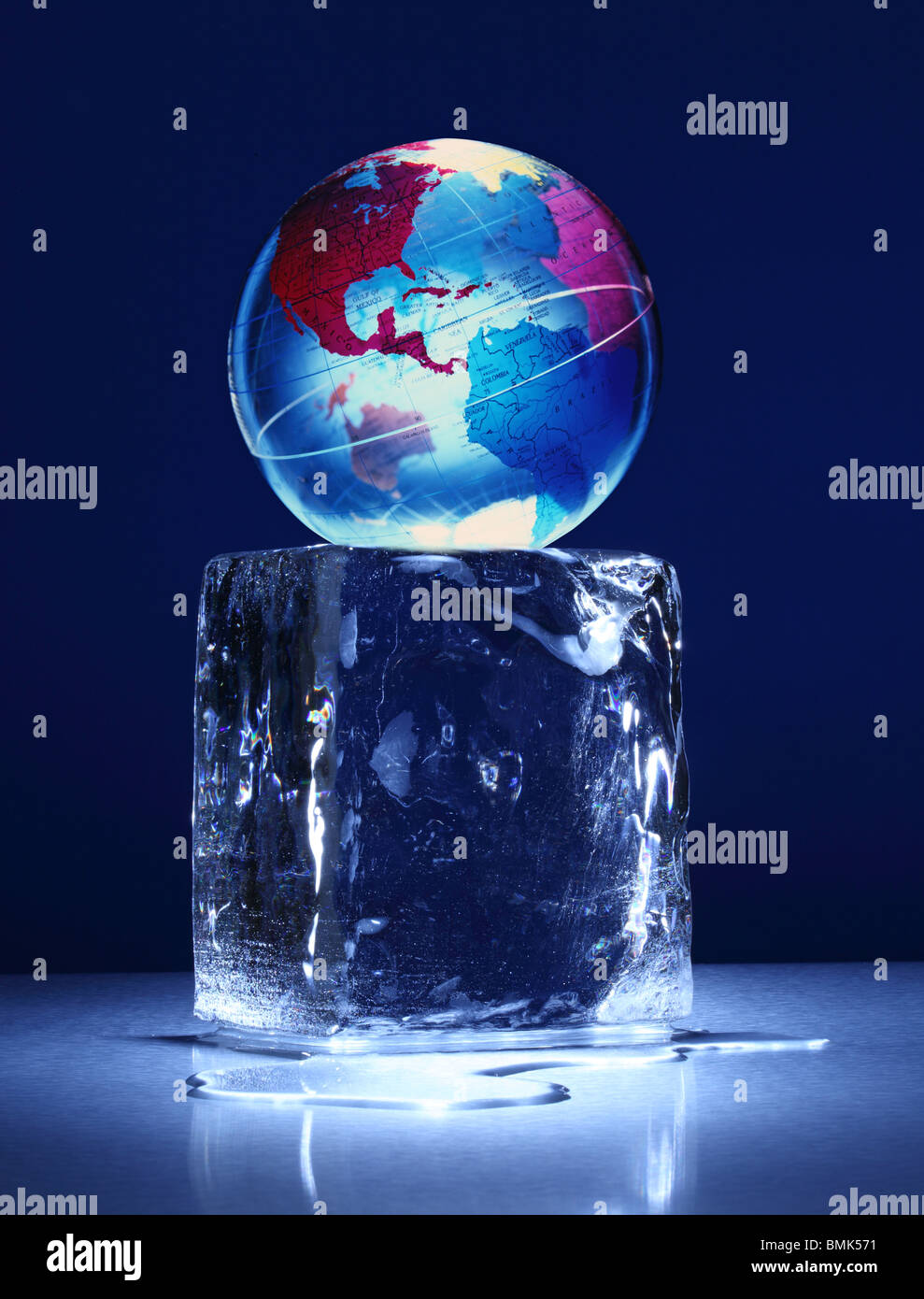 Un blocco congelato di ghiaccio con un globo mondo sulla parte superiore su una superficie di metallo Foto Stock