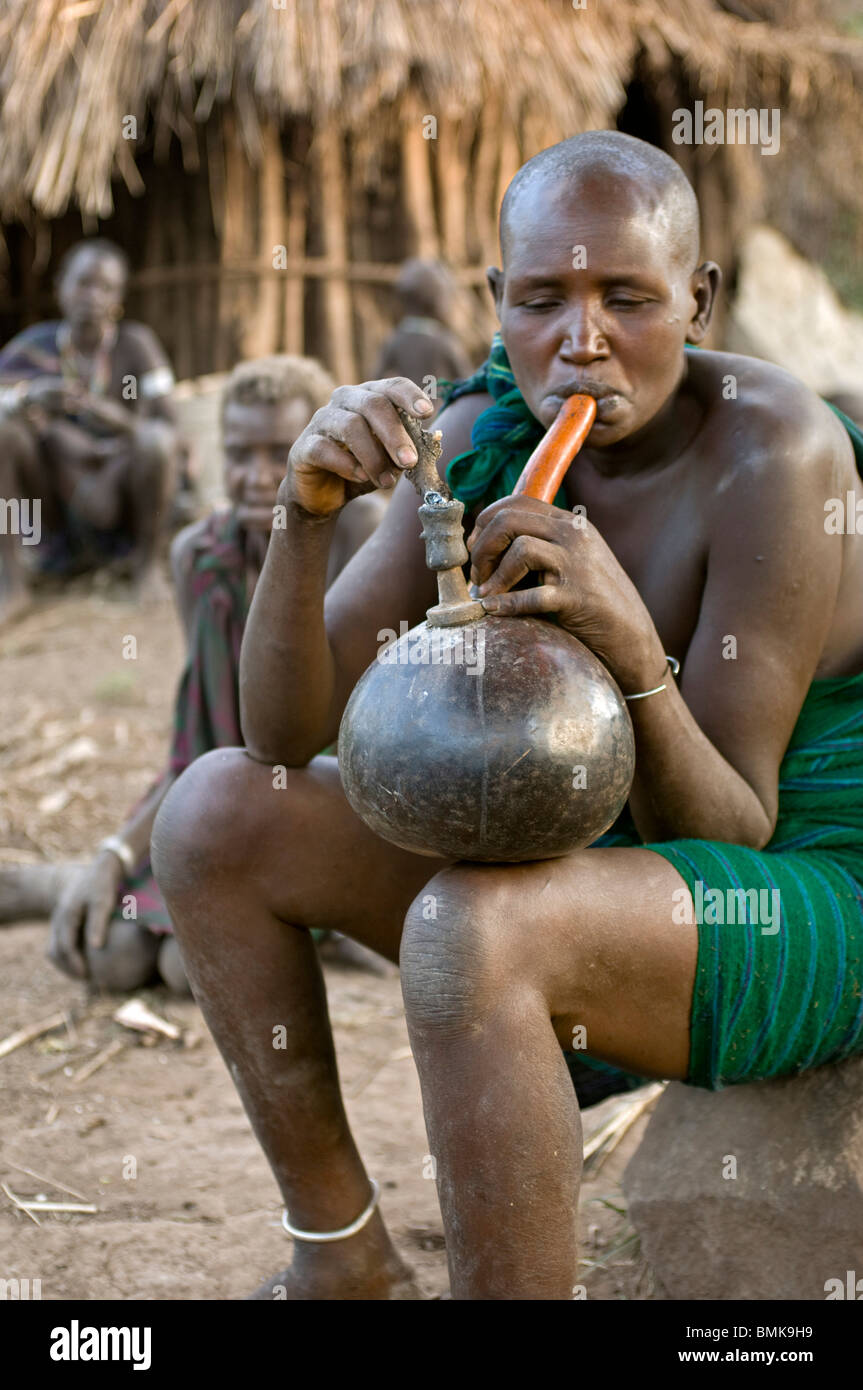 Etiopia, regione dell'Omo, Ajo village. Donna acqua fumante huka. Foto Stock