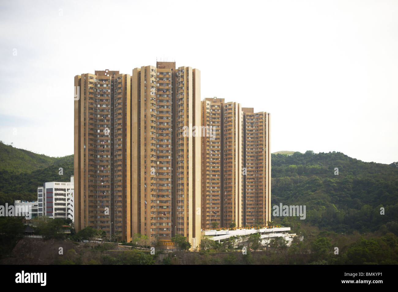 Un alto edificio di appartamenti i blocchi di costruzione di stand sulla cima di una montagna in Hong Kong. Foto Stock