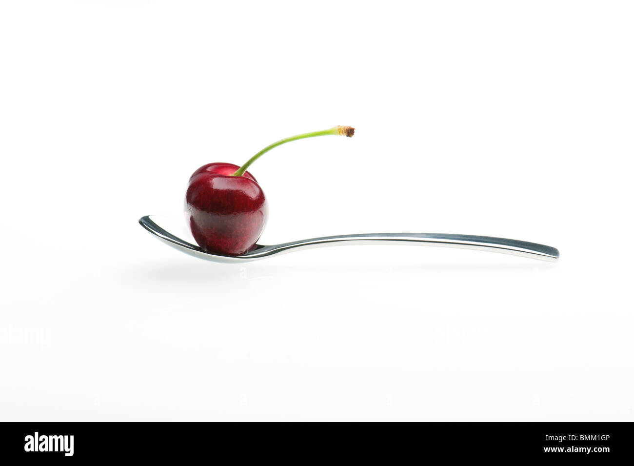 Una ciliegia fresca su un cucchiaio d'argento Foto Stock