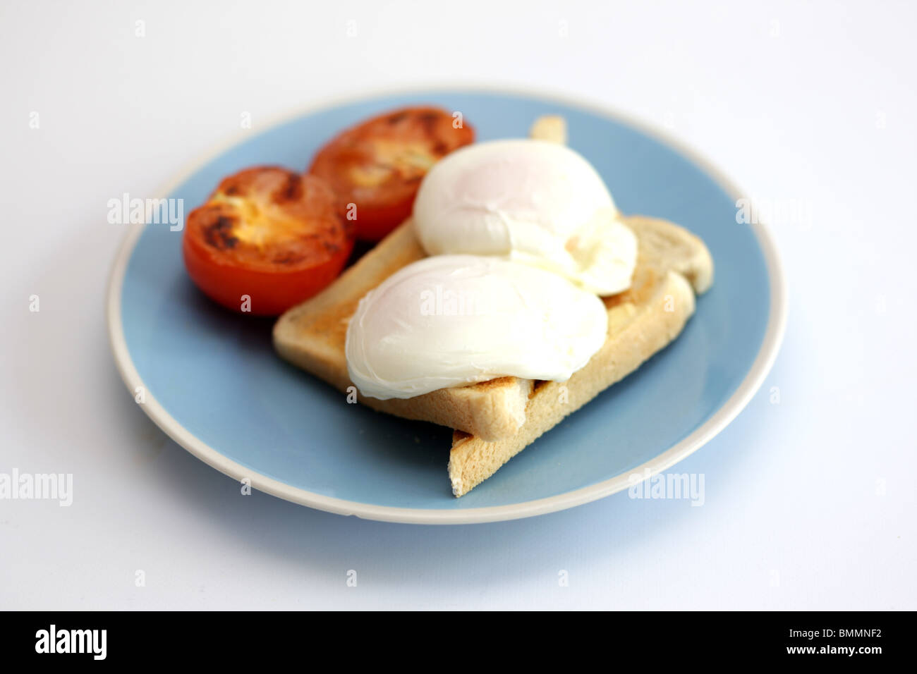 Le uova in camicia su pane tostato con pomodoro grigliate Foto Stock