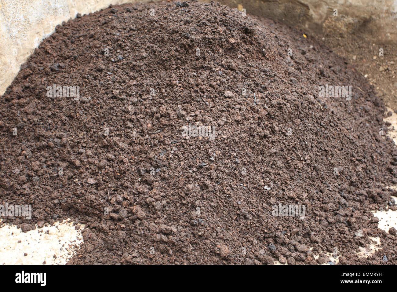 Il COMPOST setacciato attraverso un pollice a foro quadrato nella schermata statica Foto Stock