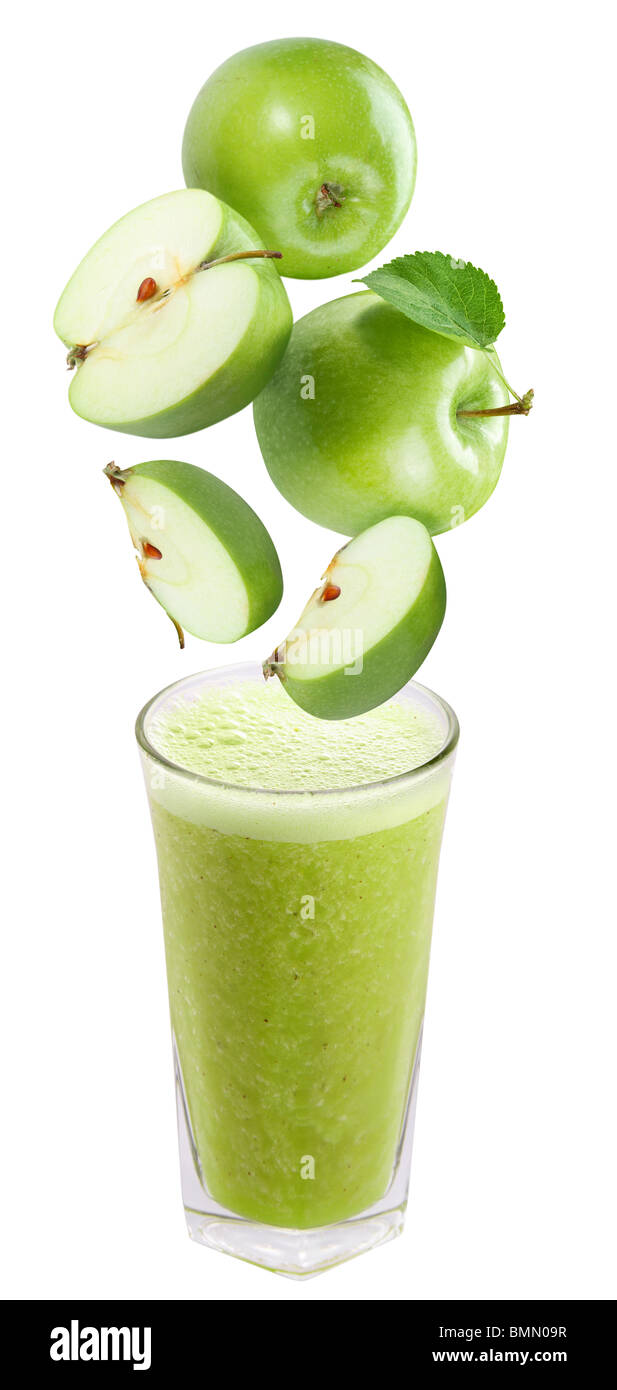 Fette di mela che cade in un bicchiere di succo di frutta fresco Foto Stock