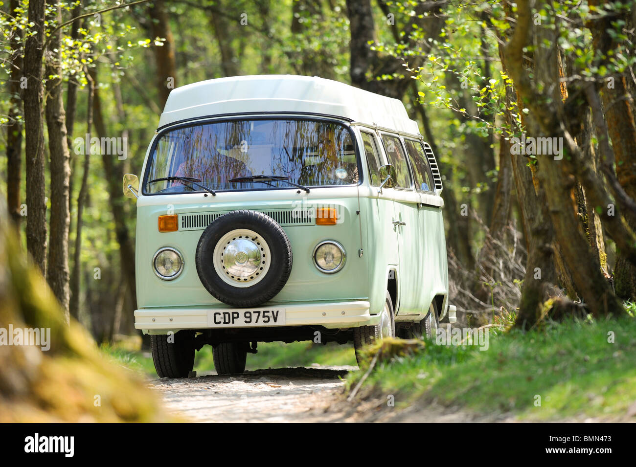 Una giovane coppia che si gode una vacanza in campeggio in un classico camper VW. Foto Stock