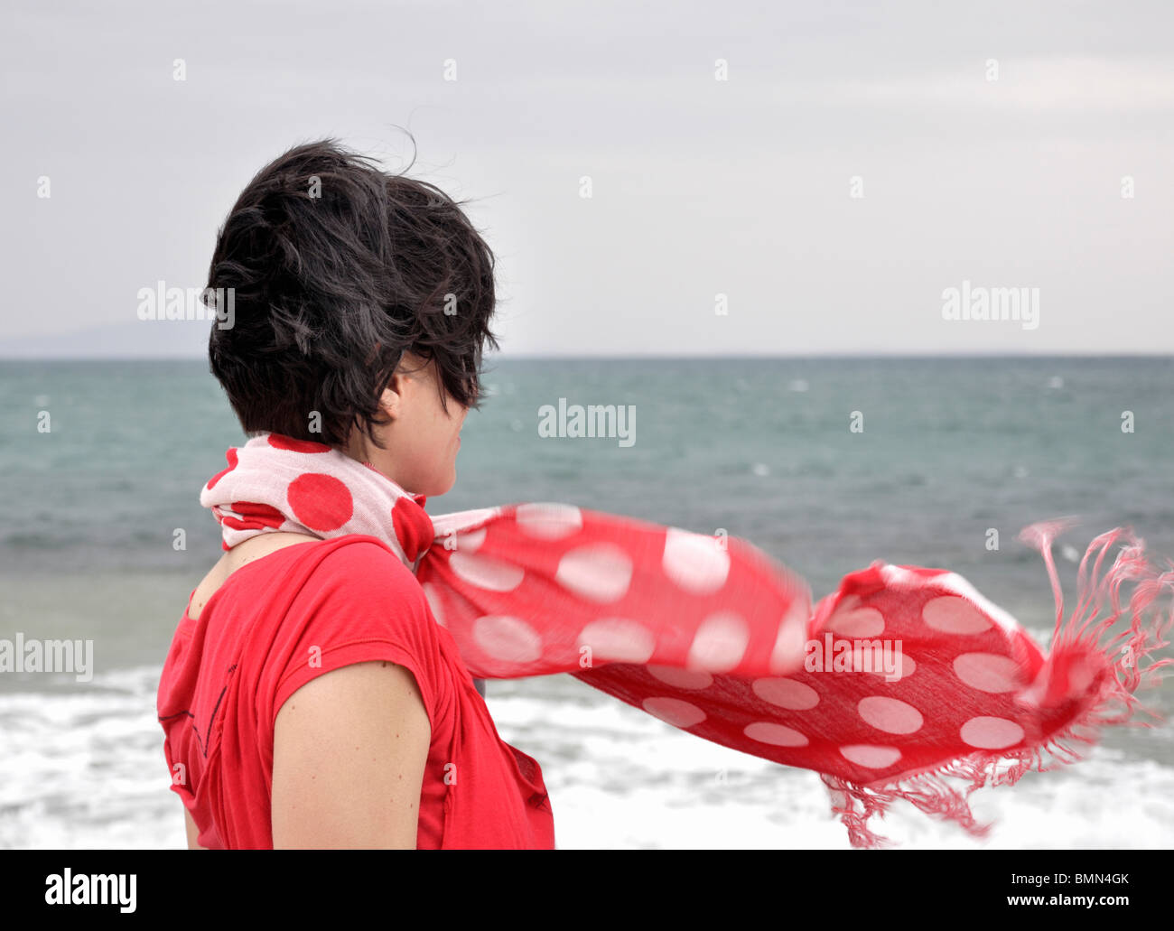 Donna con flusso di sciarpa rossa Foto Stock