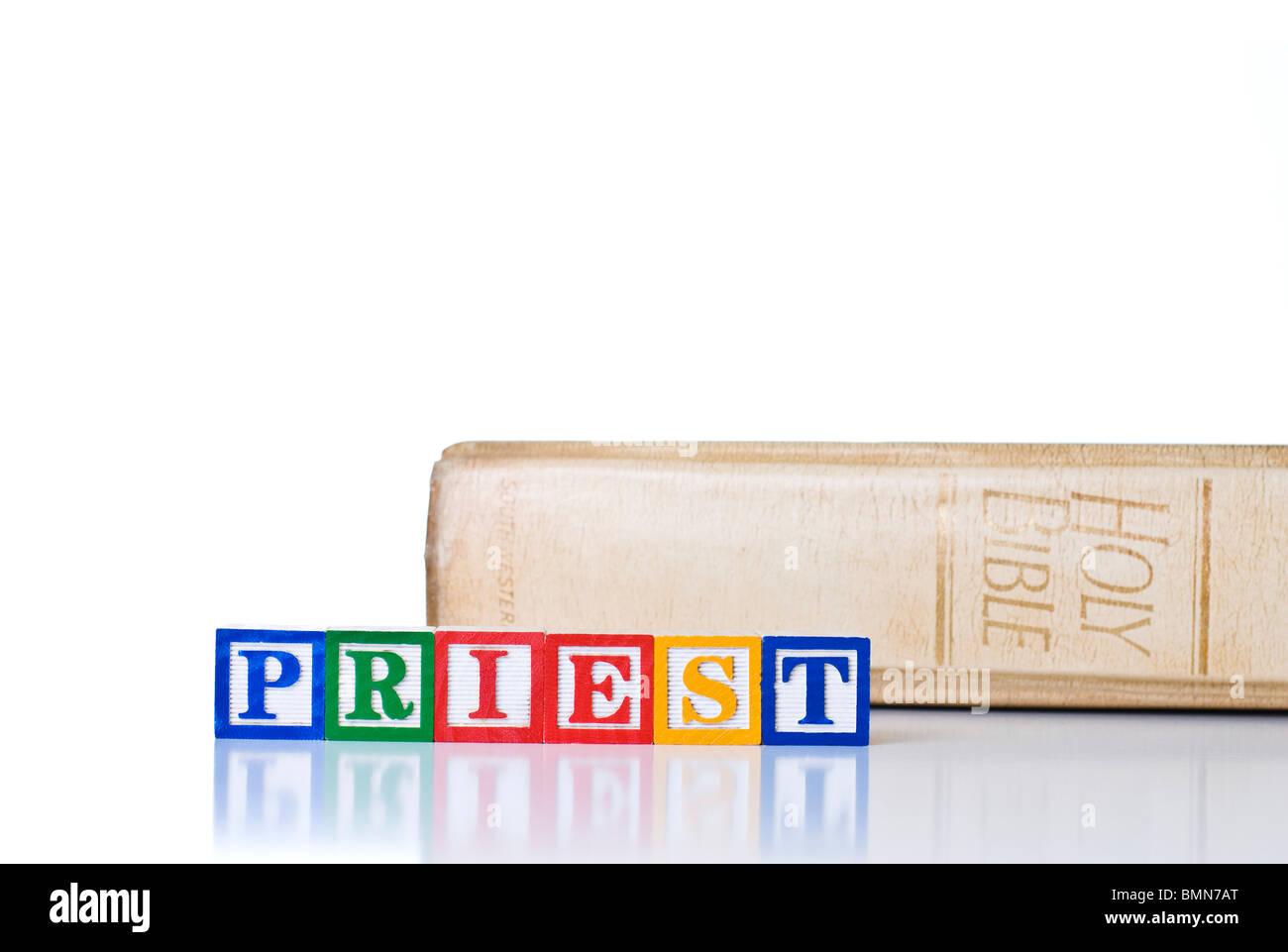 Bambini colorati blocchi del sacerdote di ortografia con una Sacra Bibbia Foto Stock