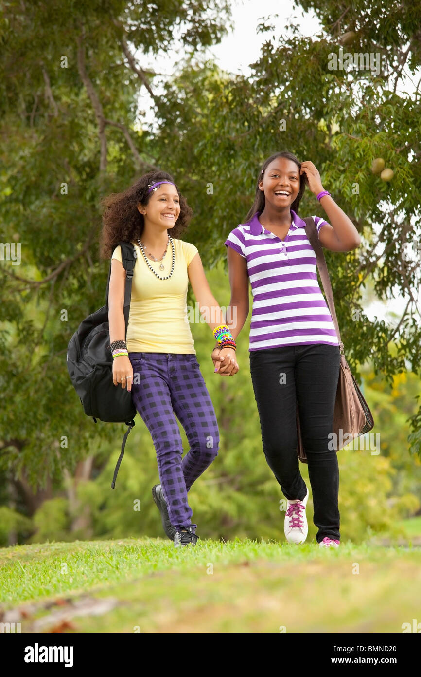 Fort Lauderdale, Florida, Stati Uniti d'America; due ragazze adolescenti a piedi attraverso un parco con i loro zaini Foto Stock