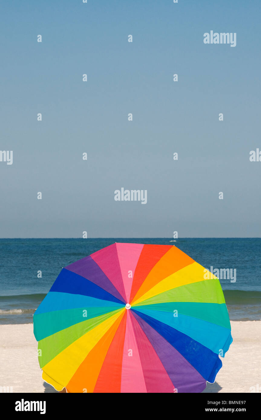 Ombrello coloratissimo sulla spiaggia di sabbia bianca Florida Foto Stock