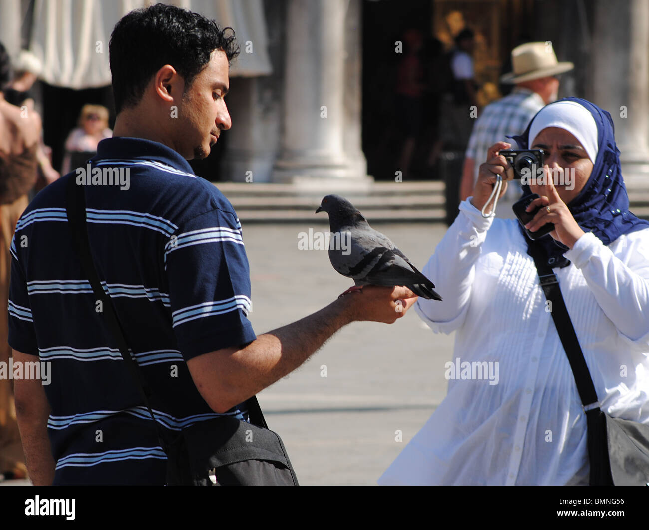 I turisti scattare foto con i piccioni in Piazza San Marco, Venezia, Italia Foto Stock