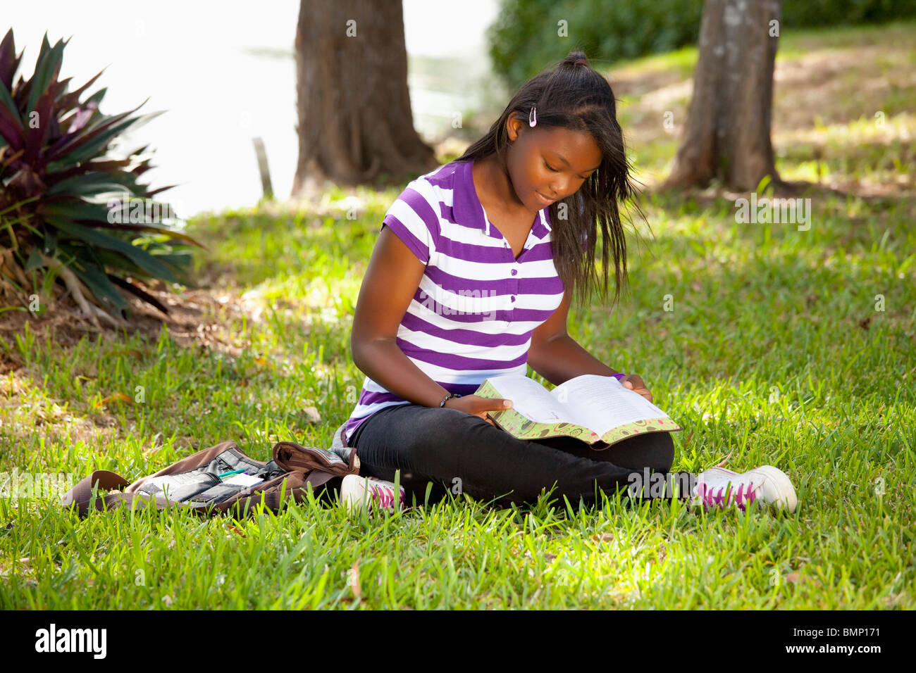 Fort Lauderdale, Florida, Stati Uniti d'America; una ragazza adolescente leggendo la Bibbia nel Parco Foto Stock