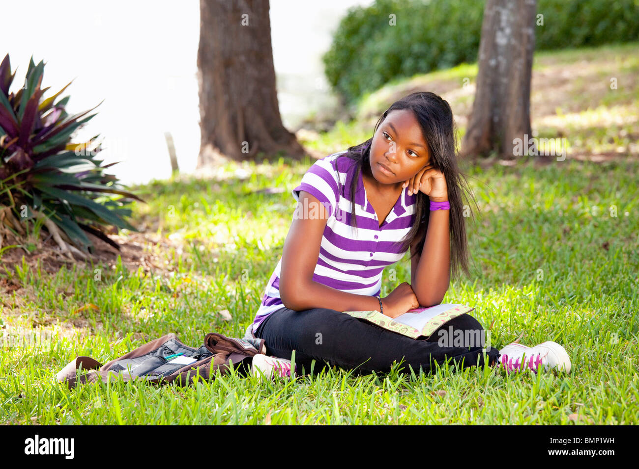 Fort Lauderdale, Florida, Stati Uniti d'America; una ragazza adolescente leggendo la Bibbia nel Parco Foto Stock