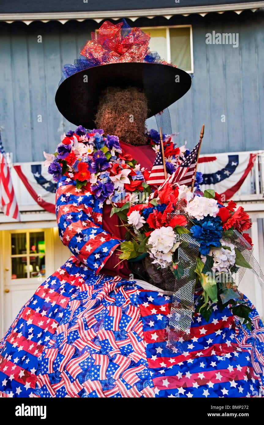 La flora, il fiore Lady è decked out in abbigliamento patriottica e trattiene le bandiere e un rosso, bianco e blu bouquet. Foto Stock