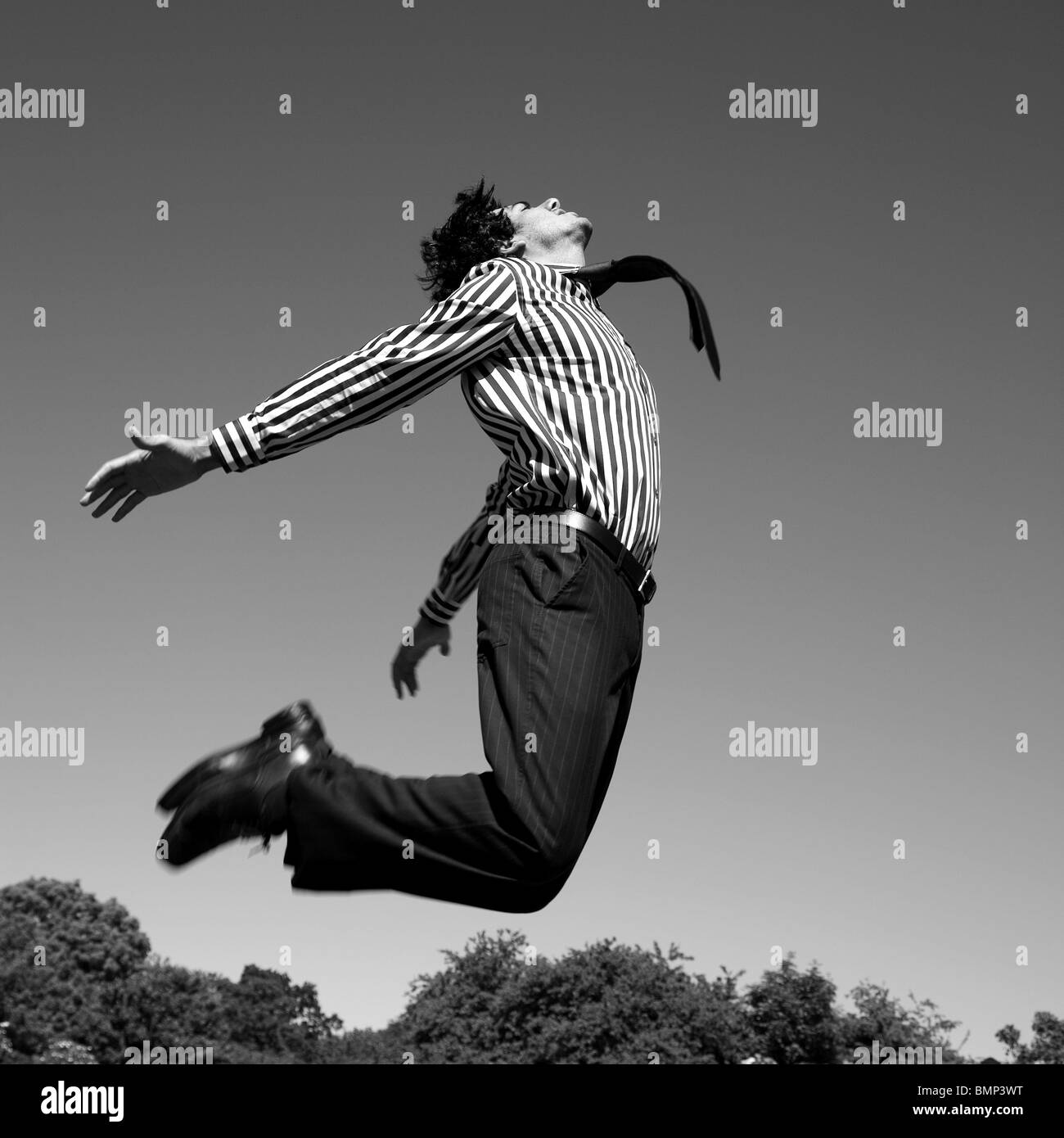 Executive uomo jumping nel cielo - nero n immagine bianco Foto Stock