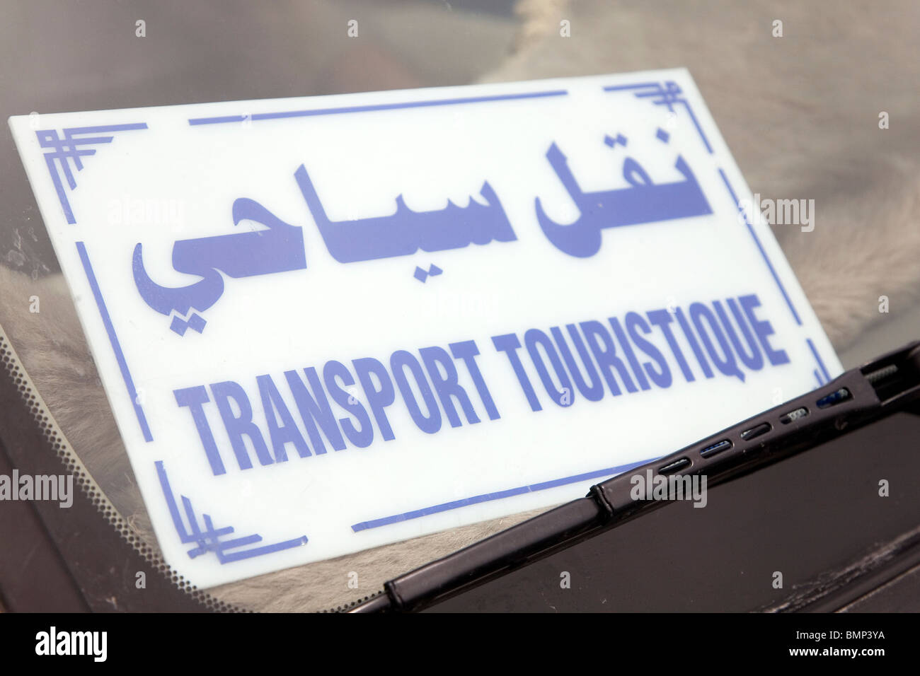 Un segno in arabo e in francese è visibile attraverso il parabrezza di un auto in Tunisia. Foto Stock