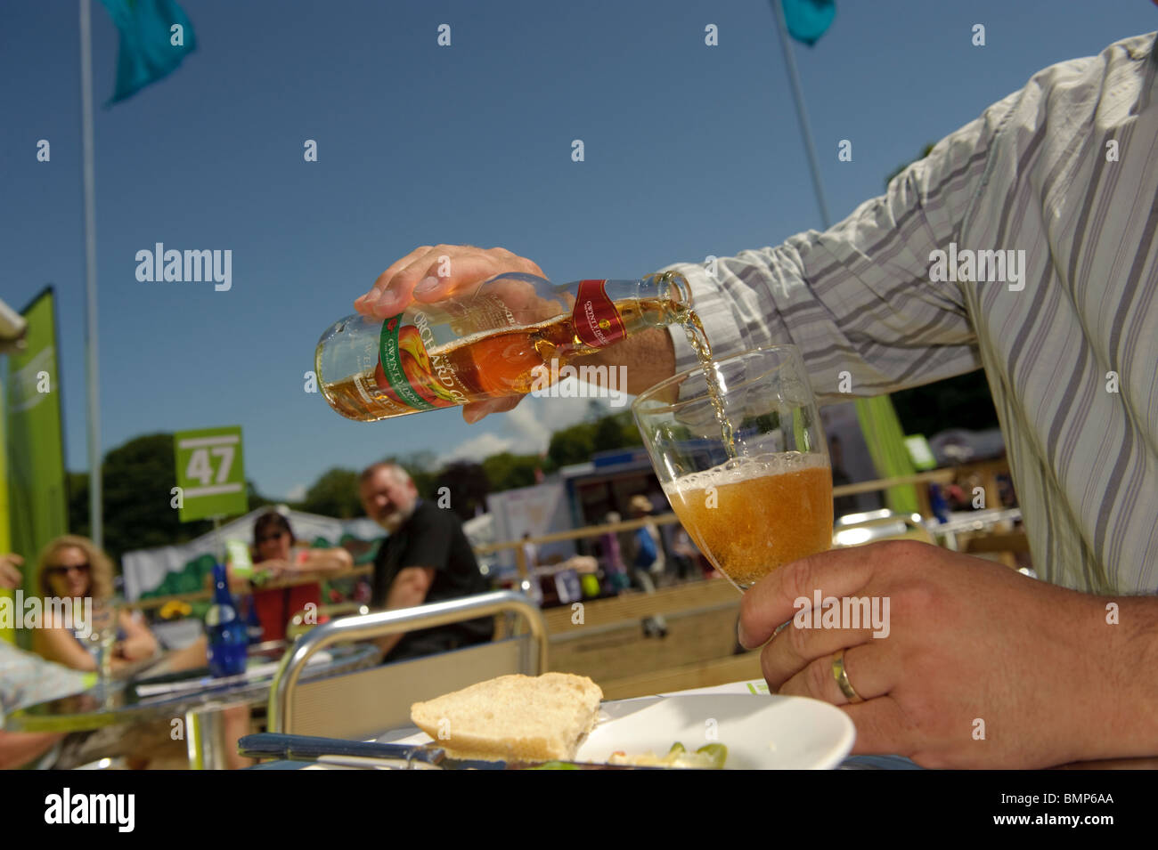 Un uomo versando un bicchiere di sidro al Urdd Eisteddfod nazionale 2010, Llanerchaeron Galles Ceredigion REGNO UNITO Foto Stock