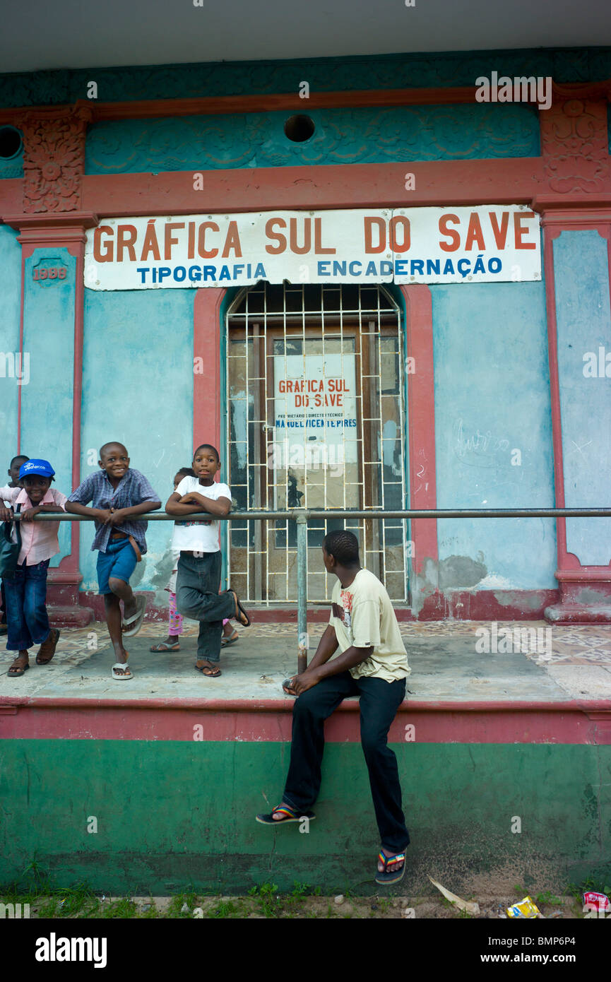 I bambini nella strada di fronte a una tipografia store di Inhambane, Mozambico, Africa Foto Stock