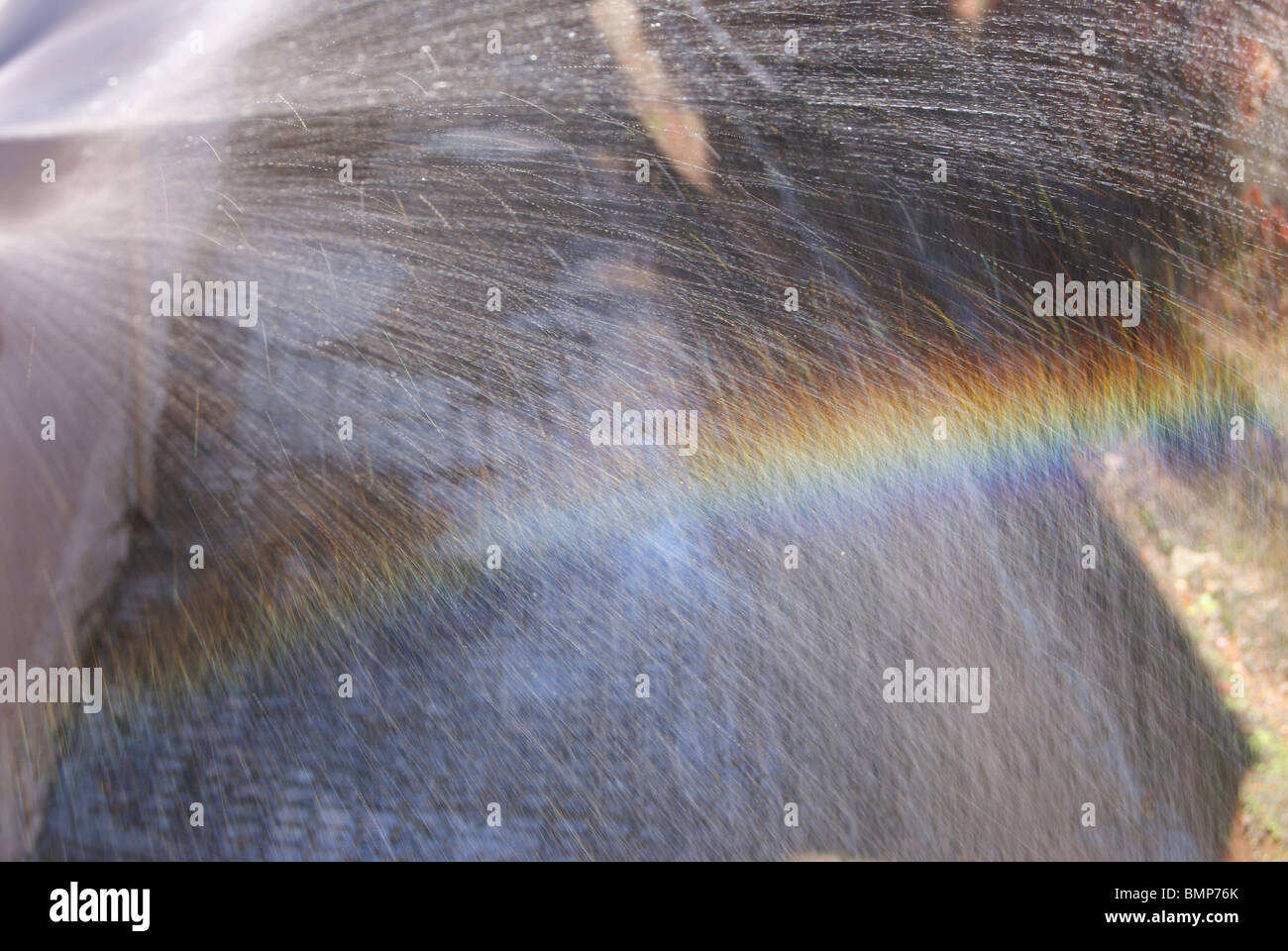 Bellissimo Arcobaleno formazione dalla bella spolverata di acqua consente di caduta su un angolo particolare contro la luce solare Foto Stock