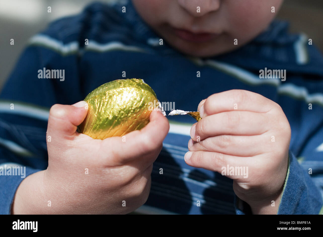 Close-up del bambino tenendo un uovo di cioccolato Foto Stock