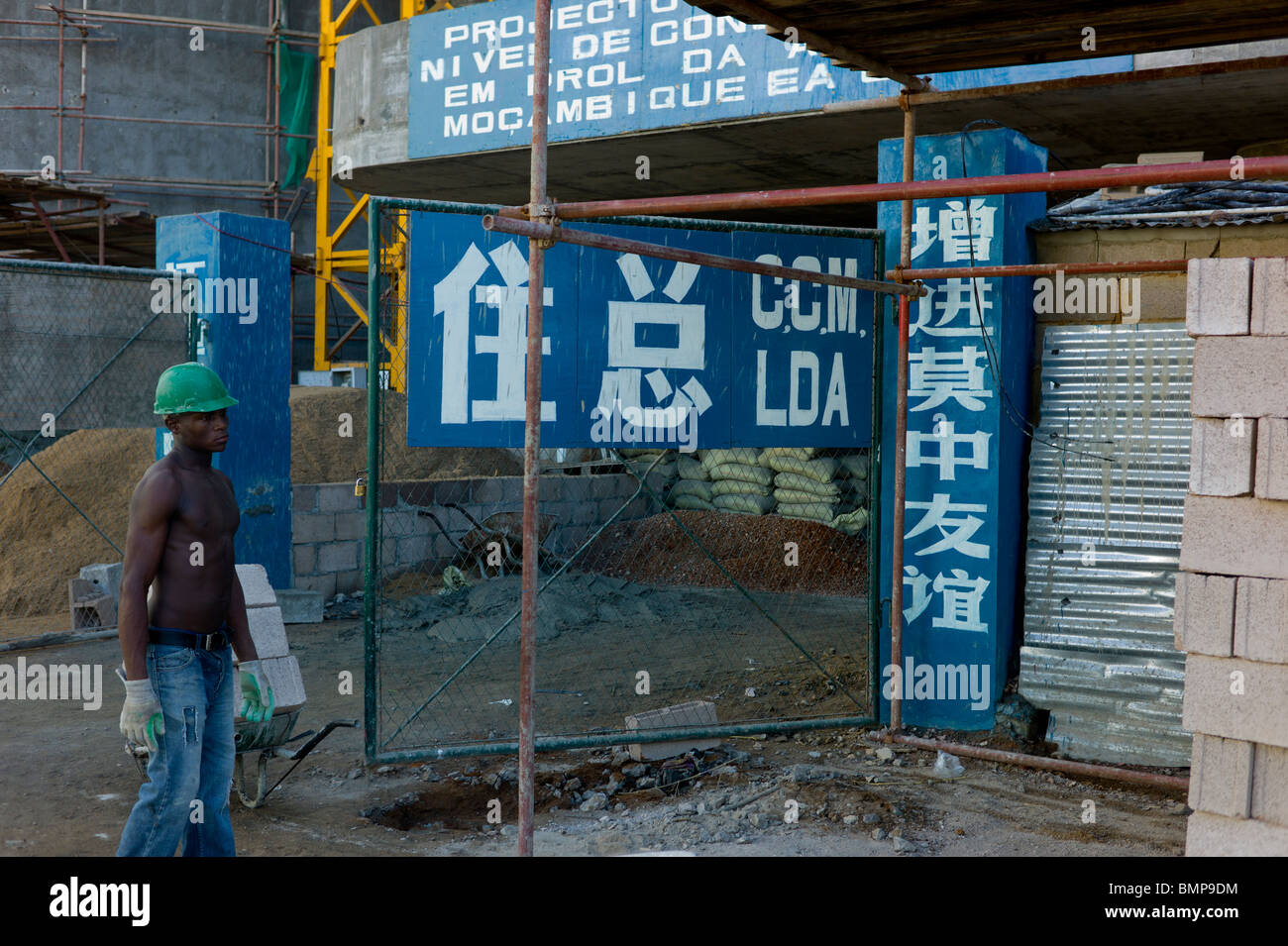 Lavoratore africano su un cinese sito in costruzione a Maputo, Mozambico. Foto Stock