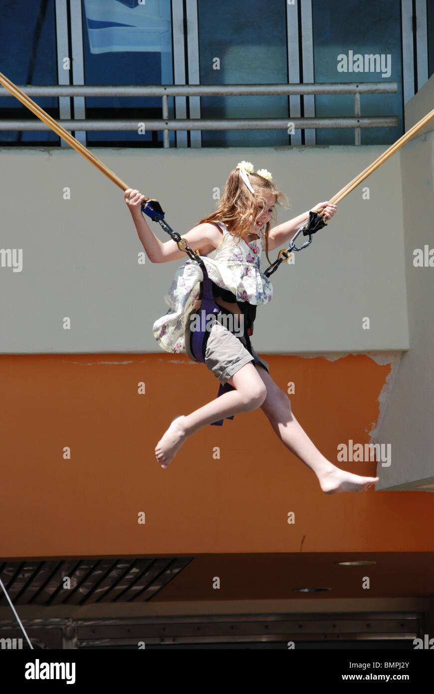 Ragazza di rimbalzo nella culla su un trampolino nella Marina, Benalmadena Costa, Costa del Sol, provincia di Malaga, Andalusia. Foto Stock