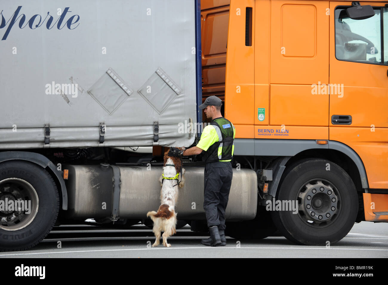 Calais Francia responsabile sicurezza controllo autocarri con sniffer dog Foto Stock