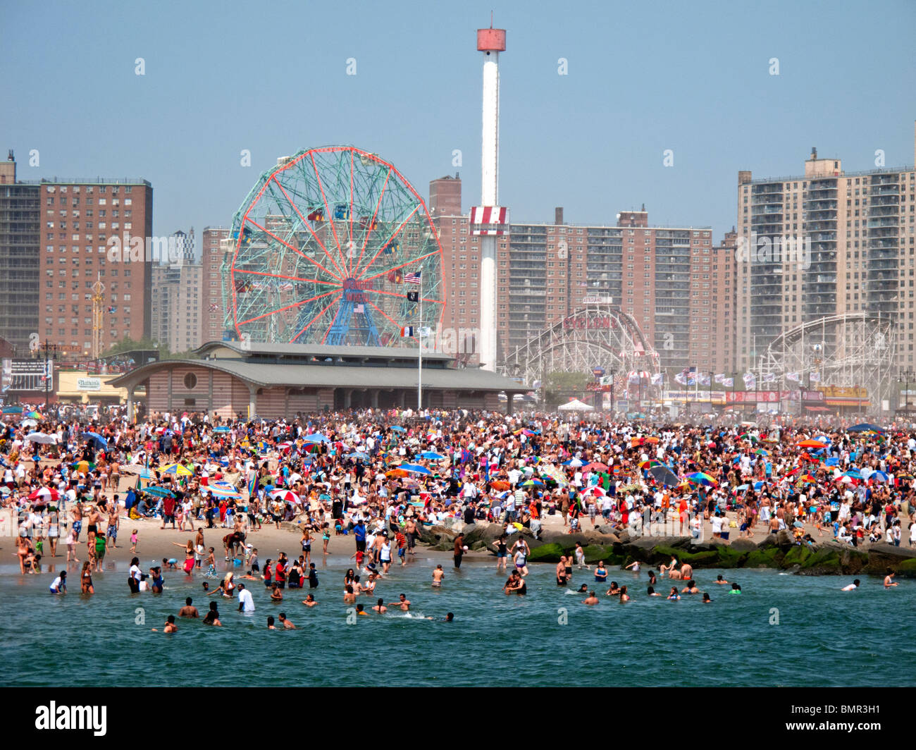 Una vacanza folla di oltre un milione di sunbathes e nuota sulla spiaggia della famosa Coney Island Amusement Park a Brooklyn, New York Foto Stock