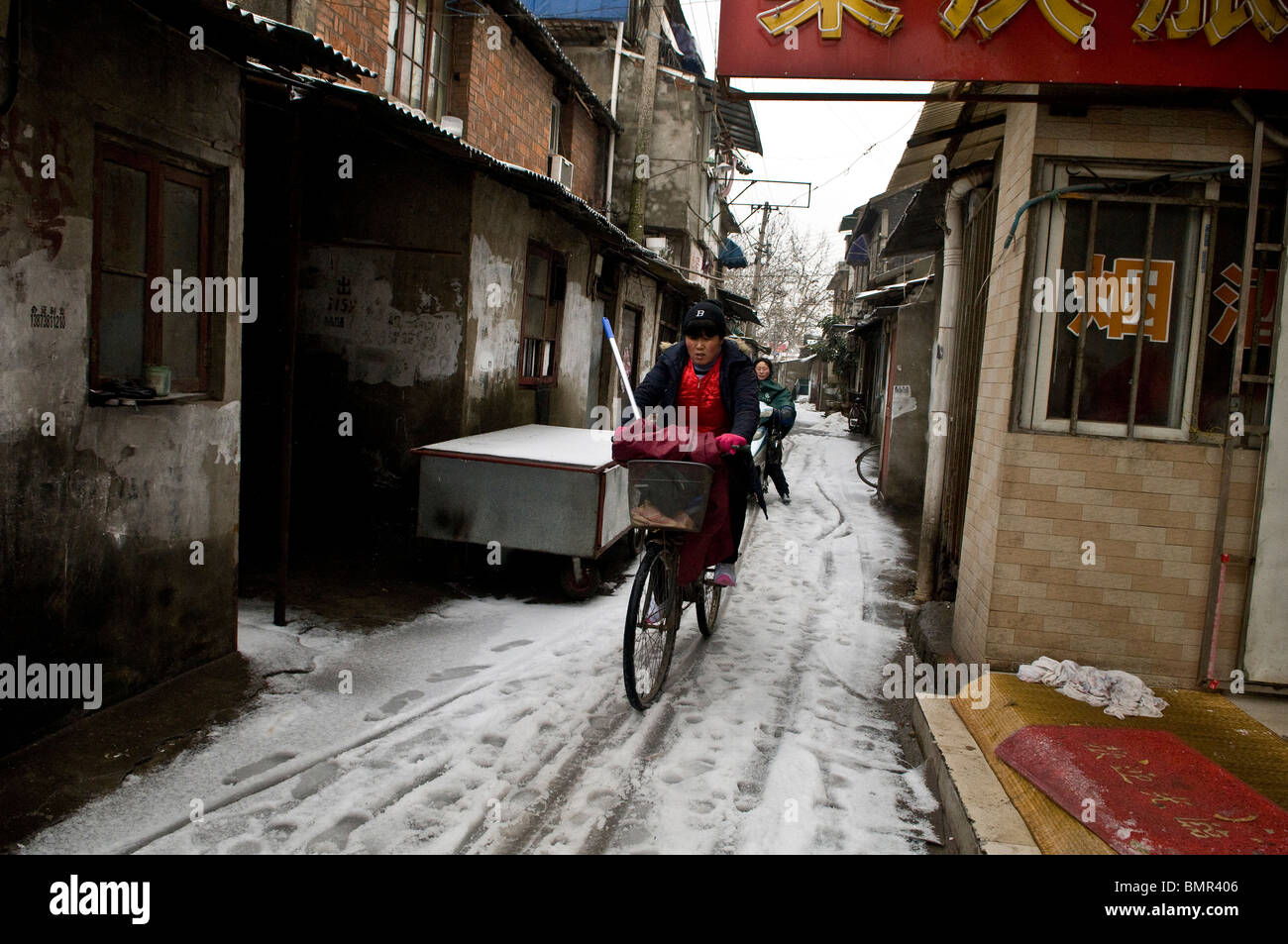 Il ciclismo sulla neve. Foto scattata in uno di Nanjing, scomparendo Hutons - vecchi quartieri. Foto Stock
