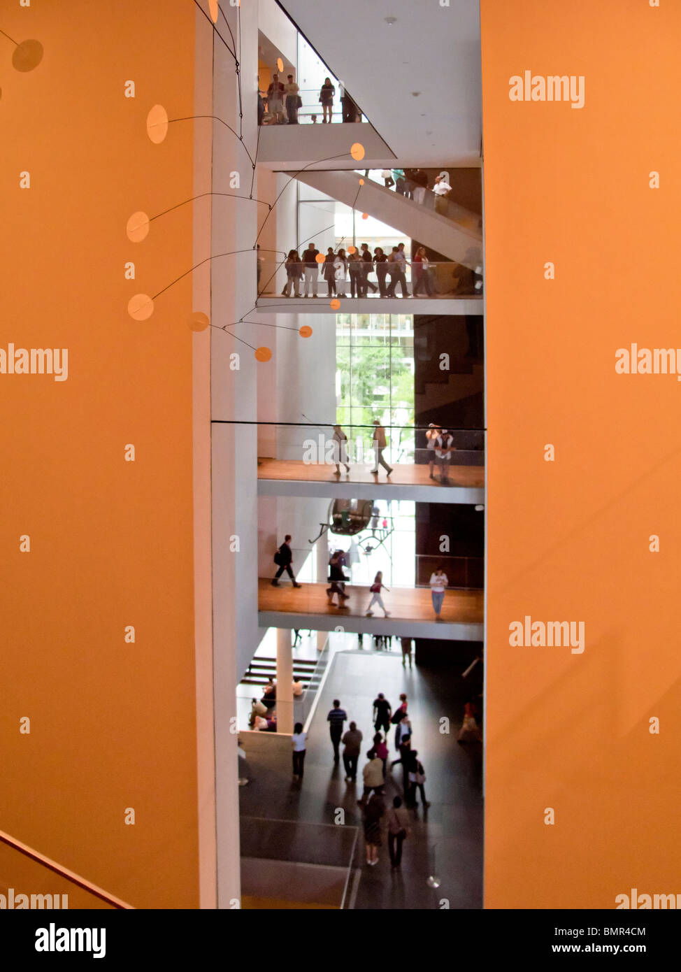 Visitatori presso il Museo di Arte Moderna di New York City a piedi su pavimenti visibile. Nota Alexander Calder mobile (in primo piano). Foto Stock