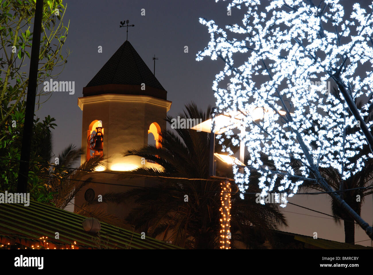 Chiesa illuminata con decorazioni di Natale in primo piano, Fuengirola, Costa del Sol, provincia di Malaga, Andalusia. Foto Stock