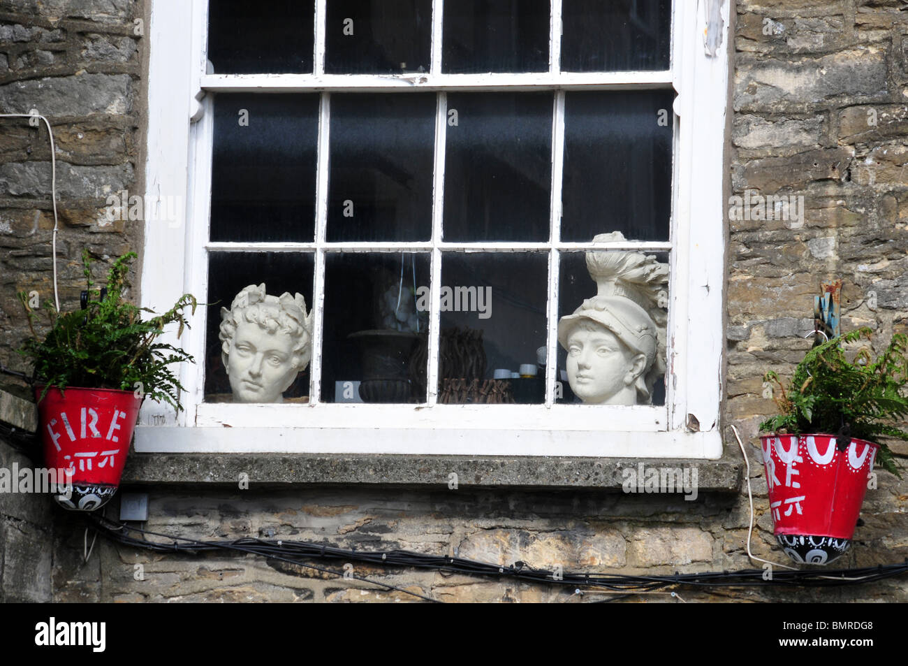 Teste ornamentali in finestra, Tetbury Gloucestershire Foto Stock