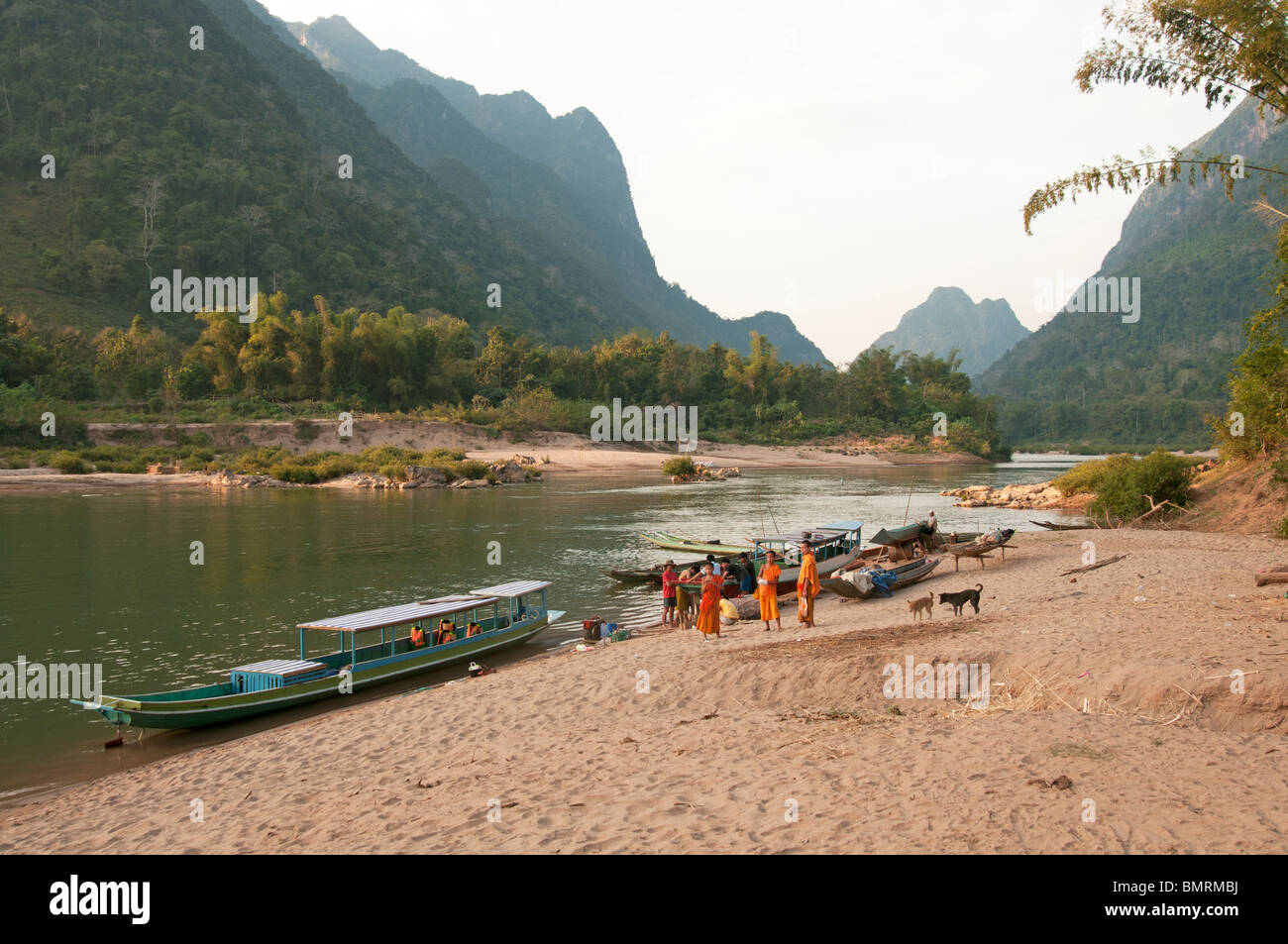 Lo zafferano derubato monaci attendere a bordo di un traghetto sul fiume sui banchi di sabbia di fiume Nam Ou nel nord del Laos Foto Stock