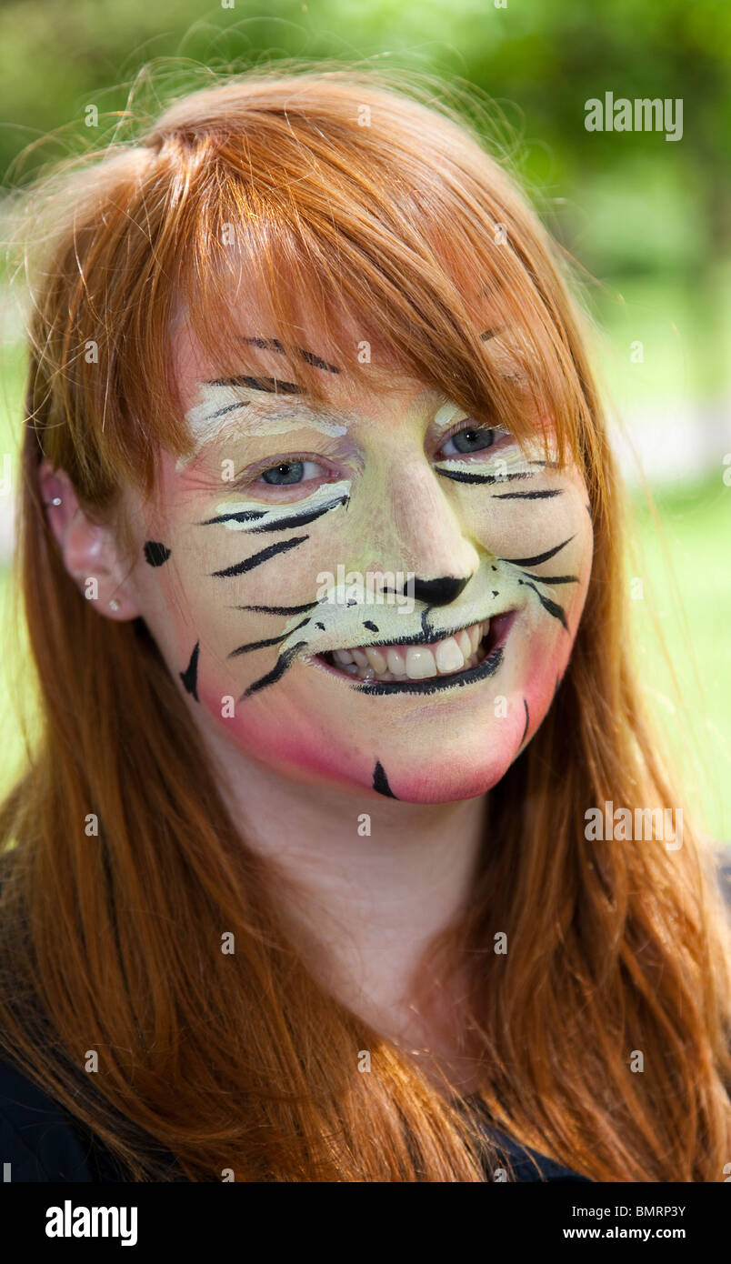 Ragazza giovane con il suo volto dipinto a guardare come una tigre al West End Festival tenutosi a Kelvingrove Park, Glasgow Foto Stock