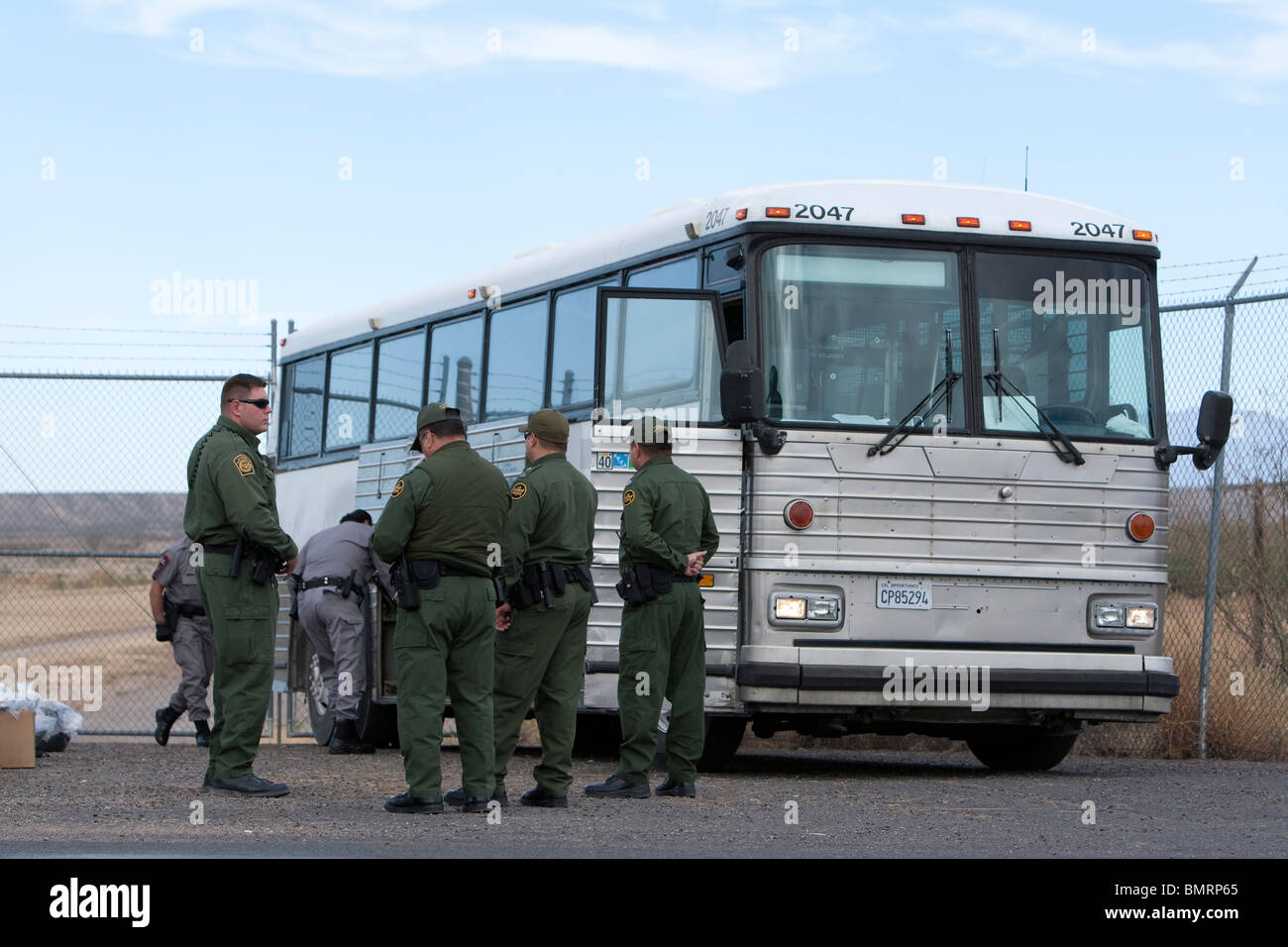 Le guardie di sicurezza guarda il trasporto di autobus stranieri illegali catturati dal Department of Homeland Security che stanno per essere inviato in Messico Foto Stock