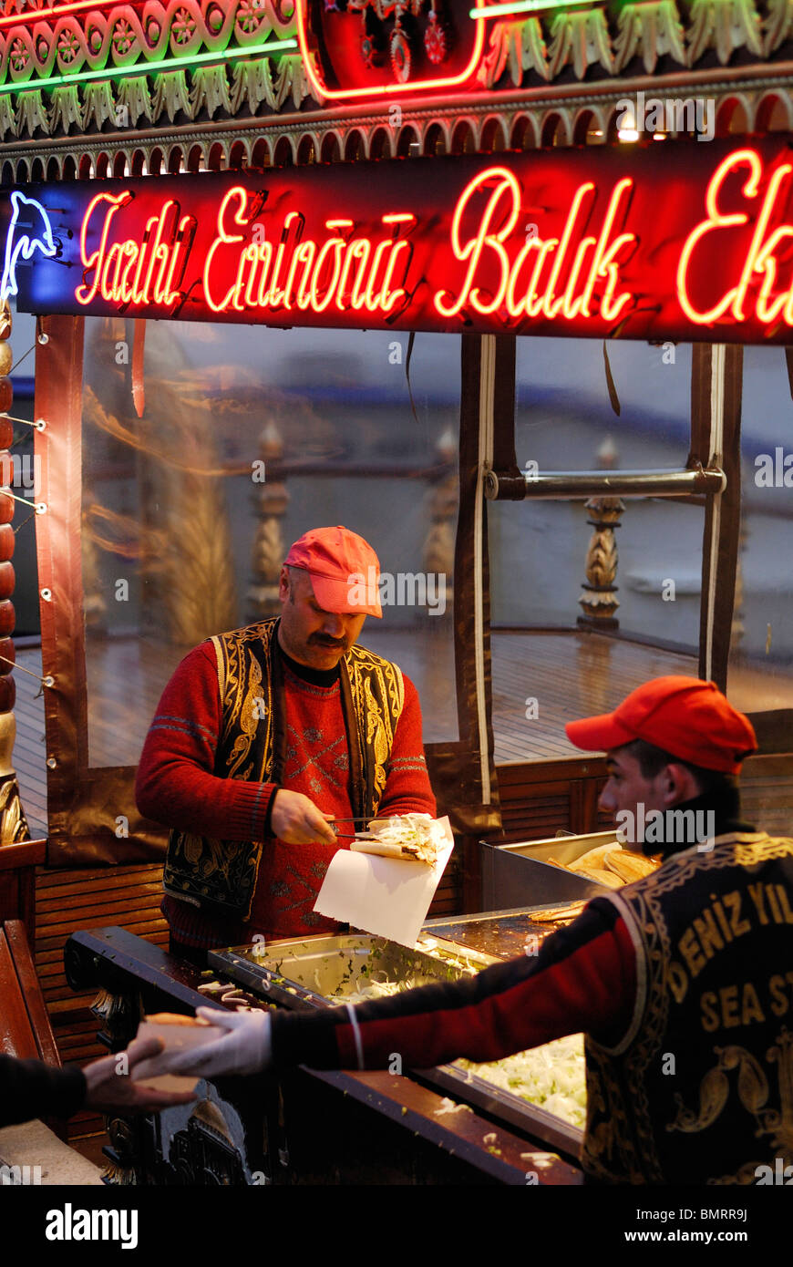 Istanbul. La Turchia. Pesce fresco panini essendo realizzata sul lungomare del quartiere Eminonu. Venditore di pesce sulla riva di Eminonu. Foto Stock