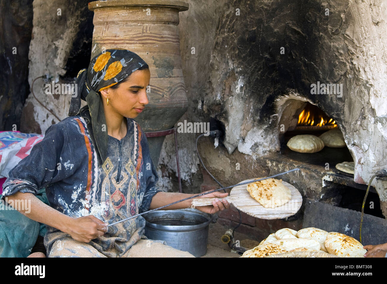 La donna la cottura del pane in un incendio tradizionali del Cairo in Egitto Foto Stock